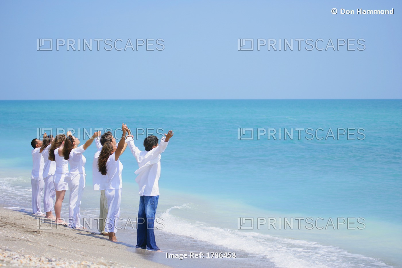 Group Of People With Arms Raised At The Seaside