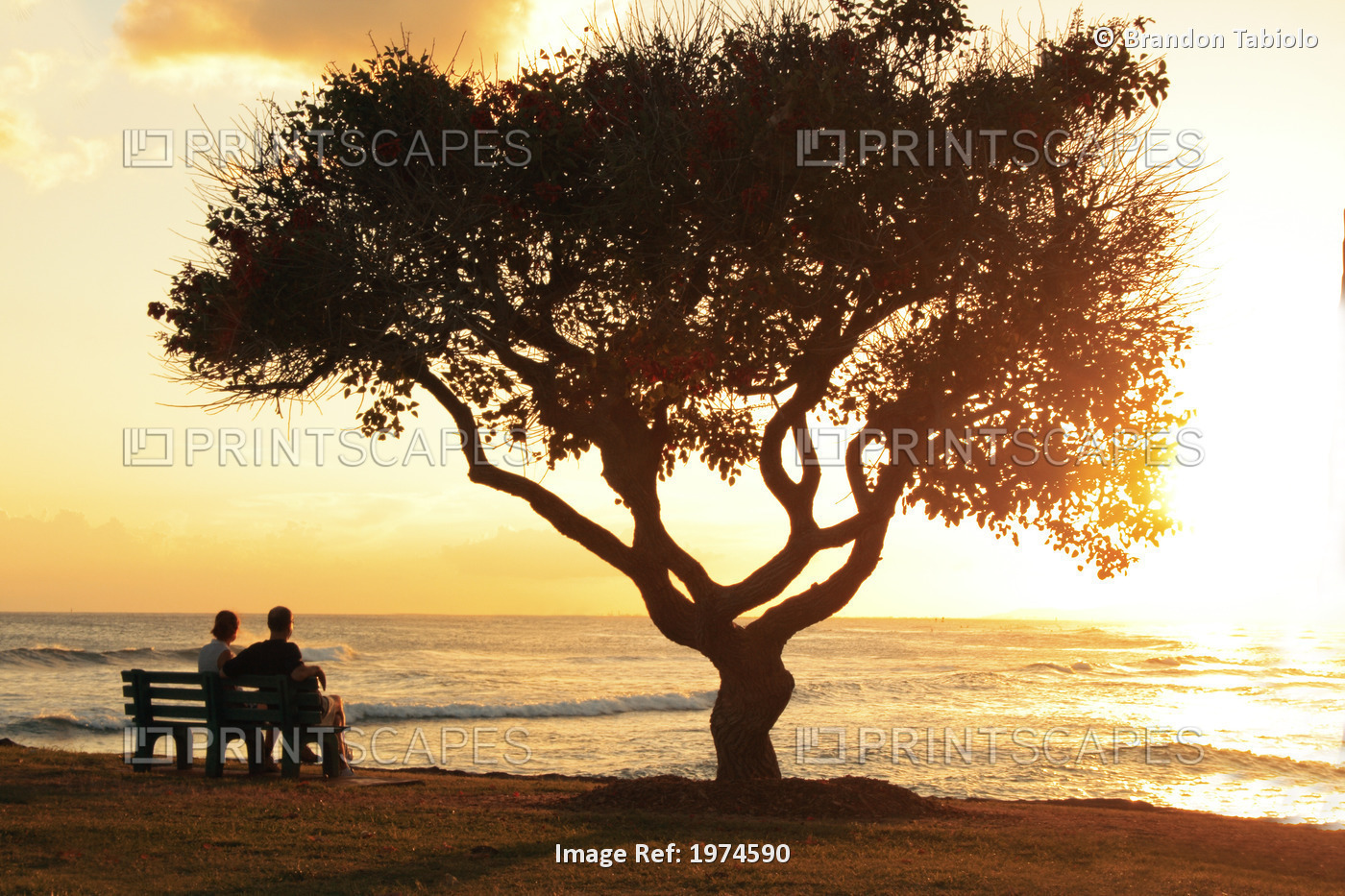 Hawaii, Oahu, Beautiful Sunset Over The Ocean With A Couple Sitting On A Bench.