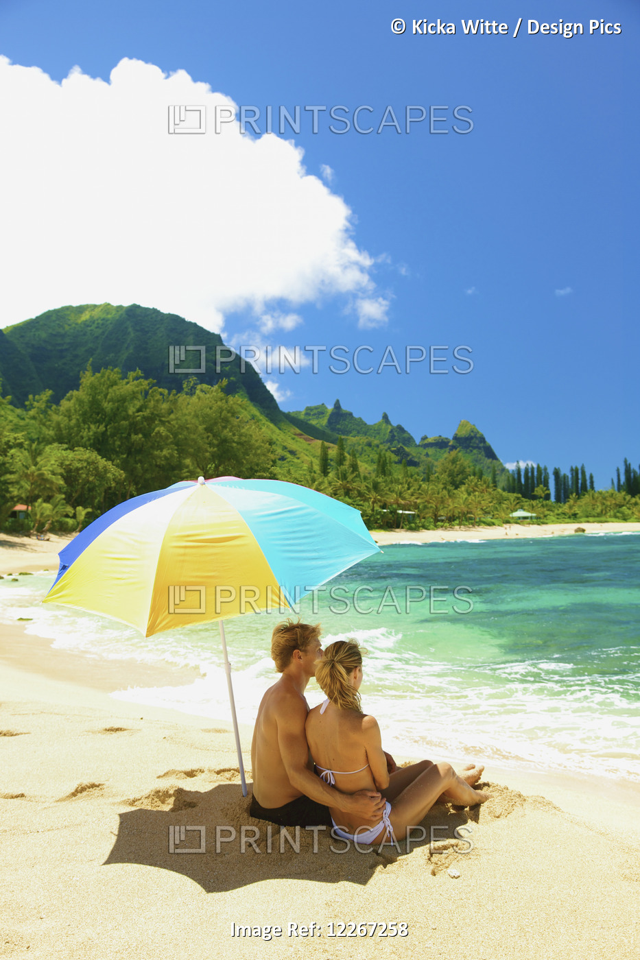 Couple Sitting Under An Umbrella At The Water's Edge; Kauai, Hawaii, United ...