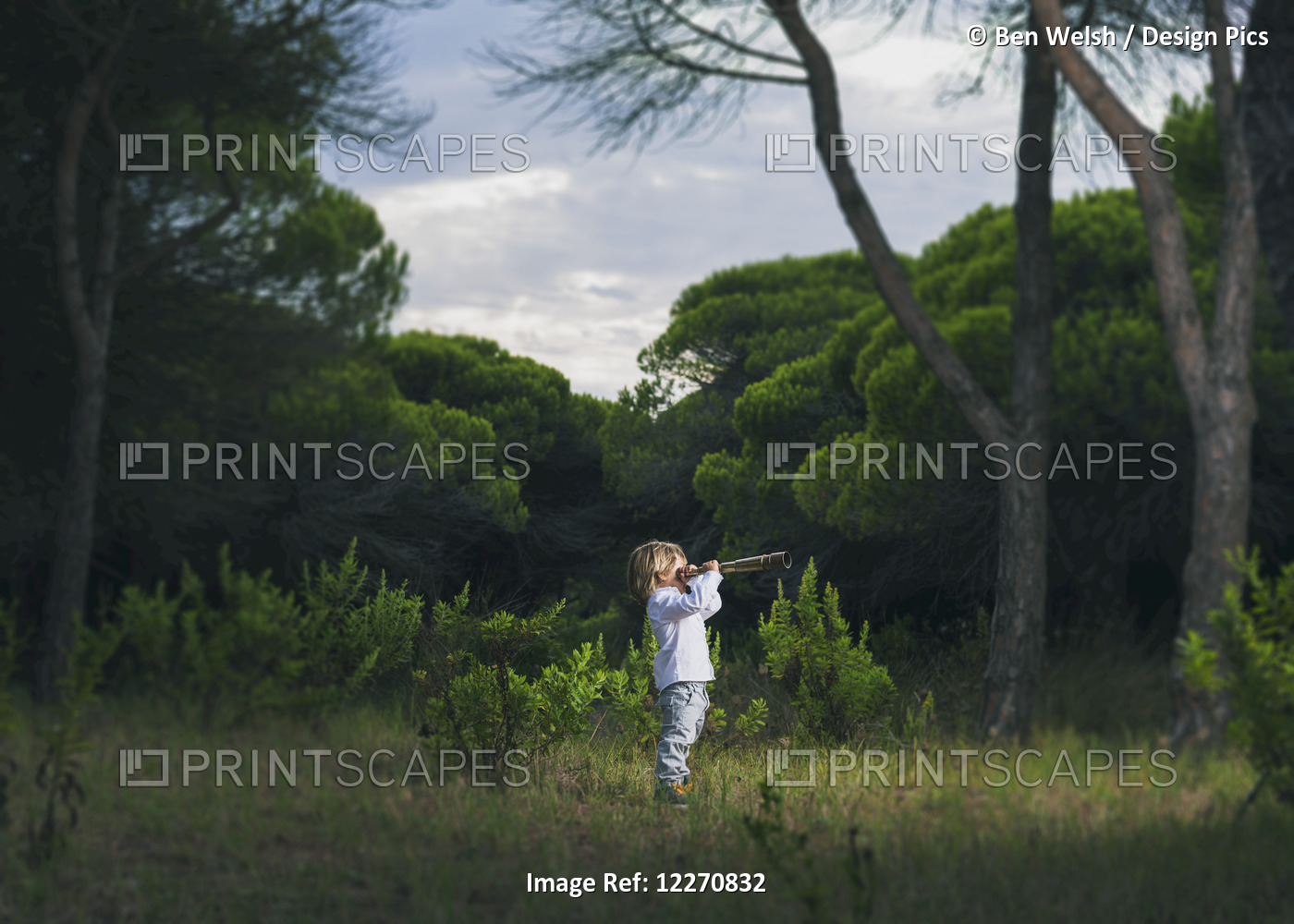 A Young Boy Looks Through A Telescope Standing In The Grass; Tarifa, Cadiz, ...