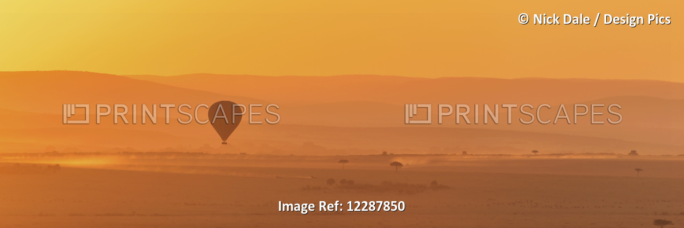 A Hot Air Balloon Flies Over The African Savannah In The Orange Light Before ...