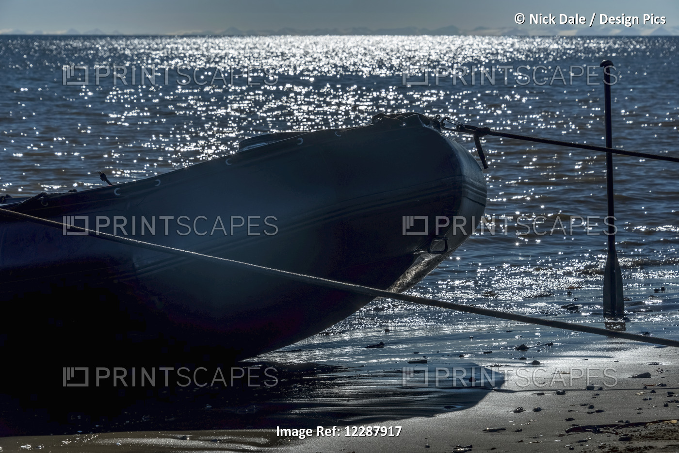 Silhouette Of A Rigid Inflatable Zodiac Moored On A Beach With A Paddle ...
