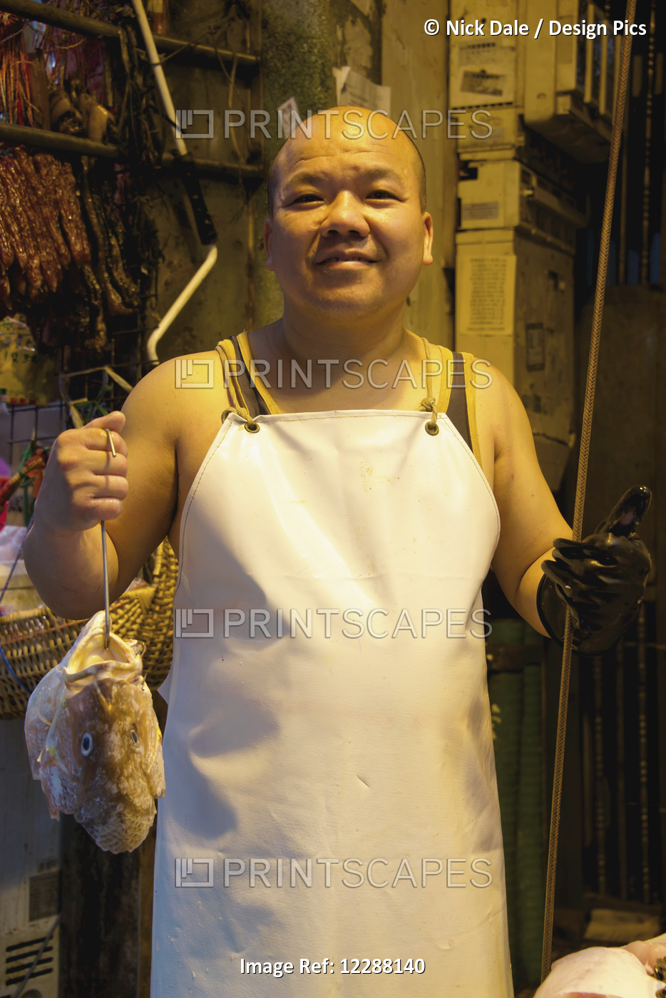 Smiling Chinese Fishmonger In Apron Holding Fish; Hong Kong, China