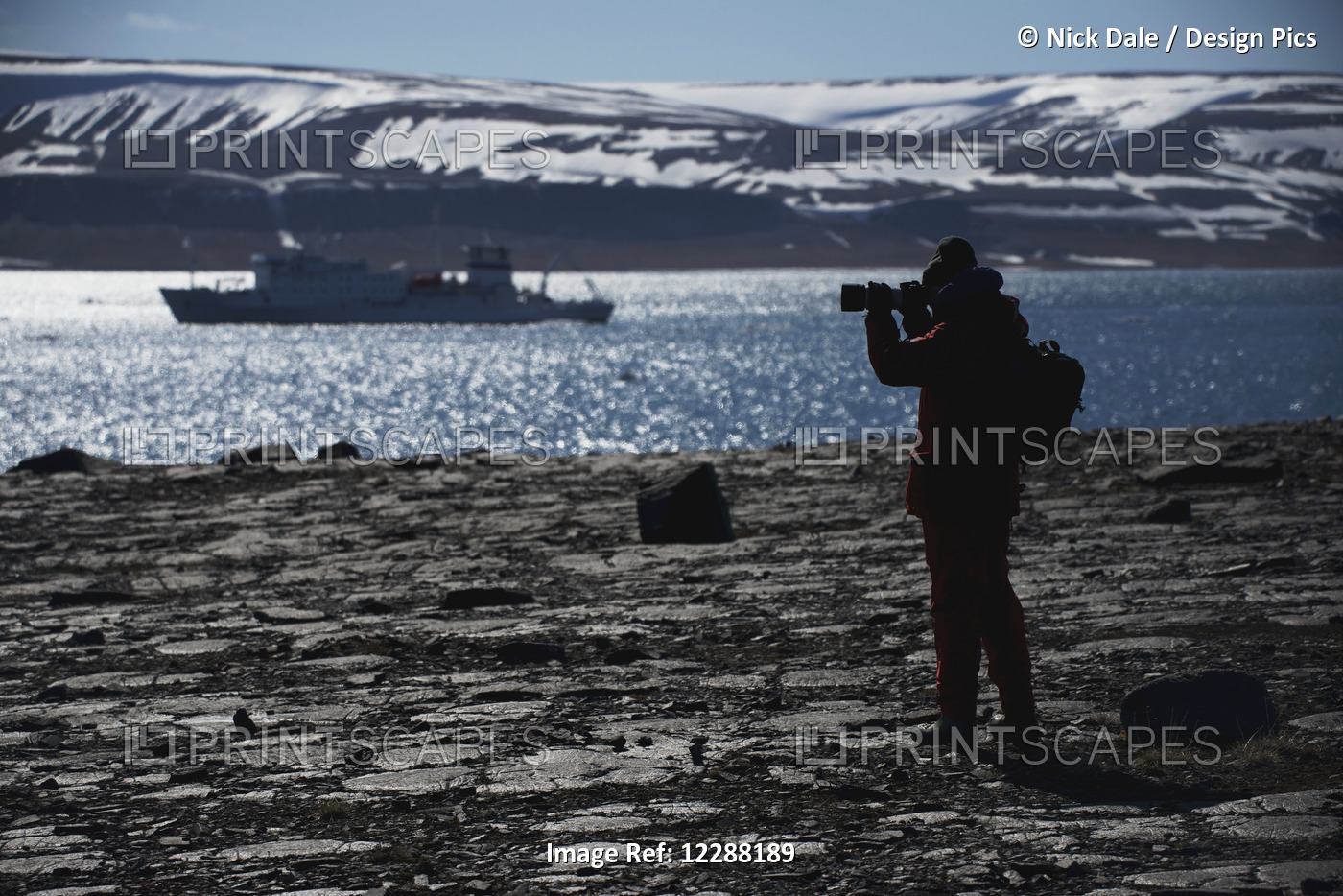 Silhouette Of Photographer Shooting Ship In Fjord; Spitsbergen, Svalbard, Norway