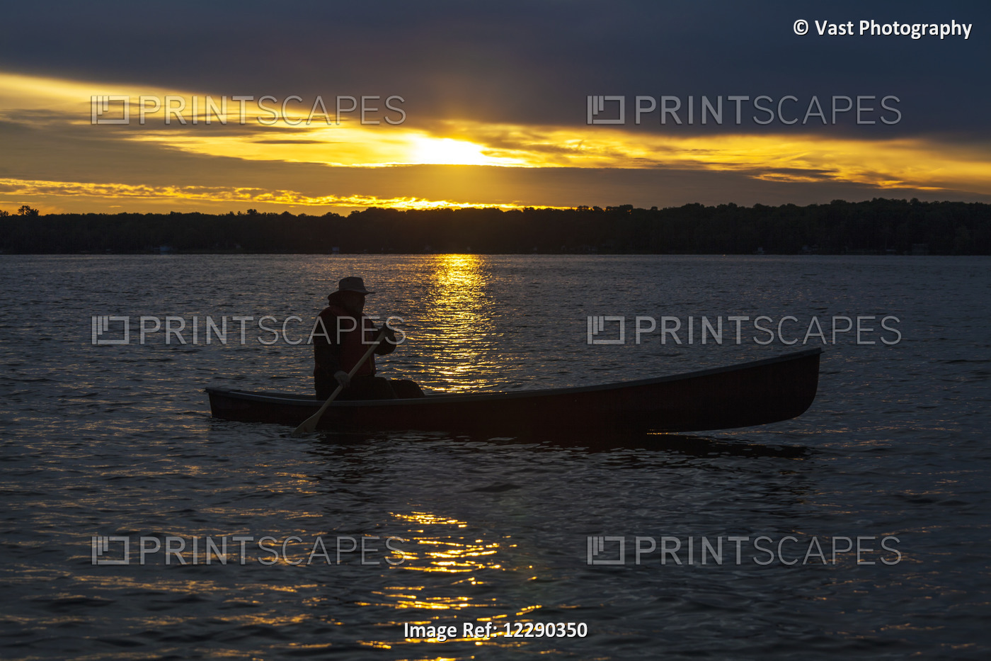 Man Paddling Canoe At Sunrise On Balsam Lake; Ontario, Canada