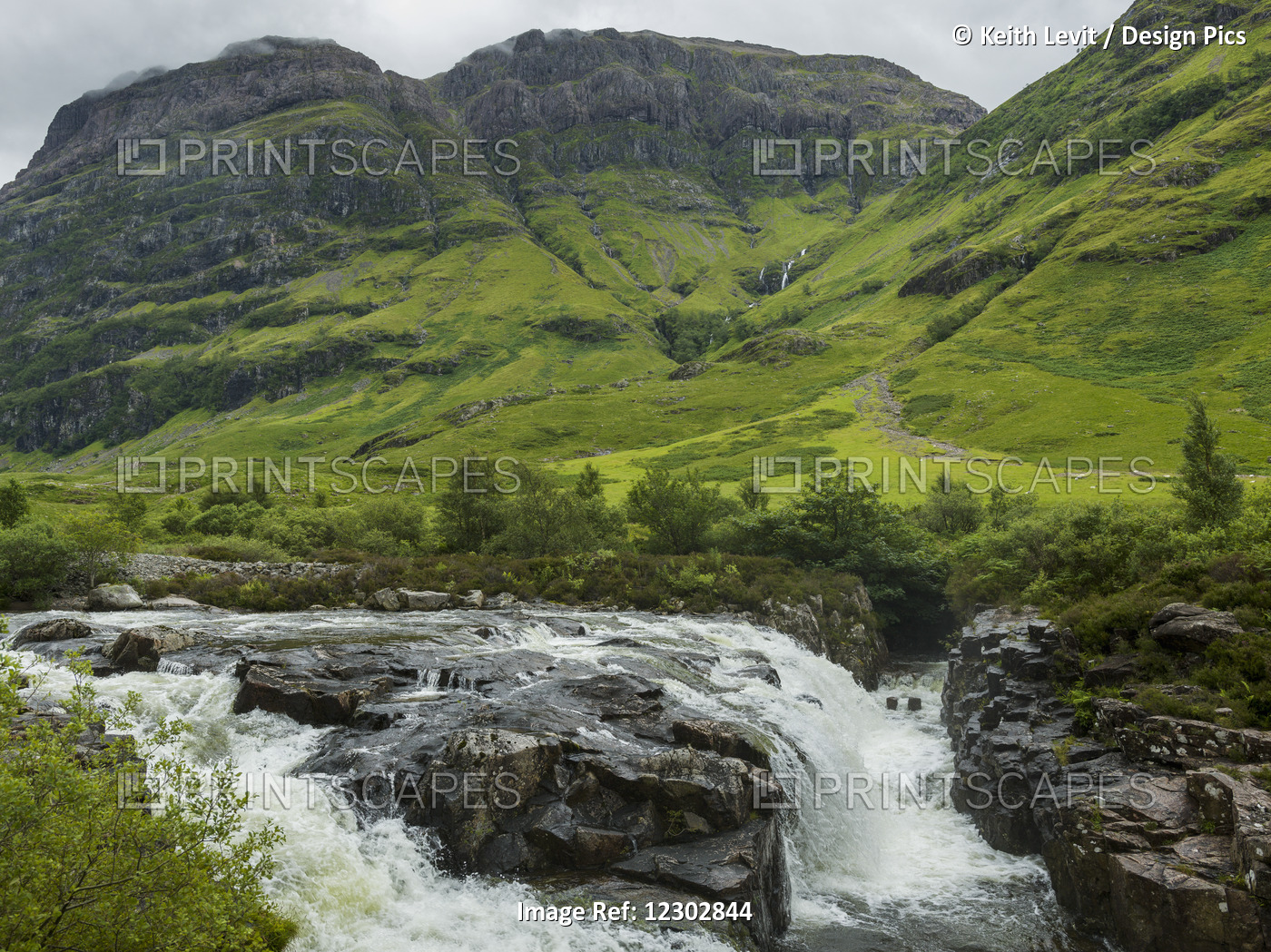 Water In A River Rushing Over Rocks And Lush Grass In The Hills; Scotland