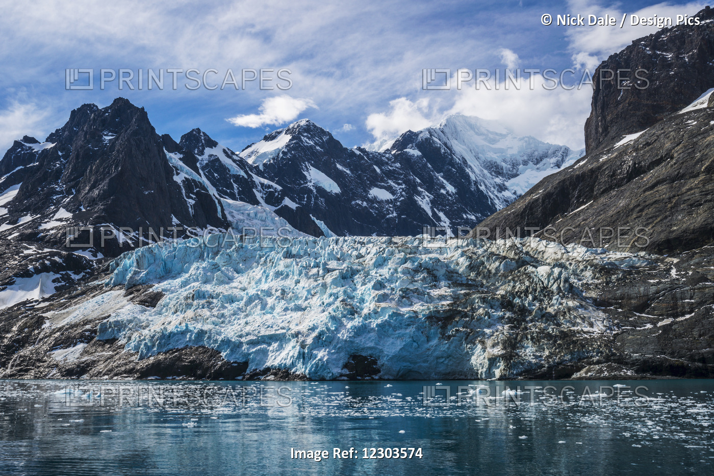 Blue Glacier Between Snow-Capped Mountains And Fjord; Antarctica