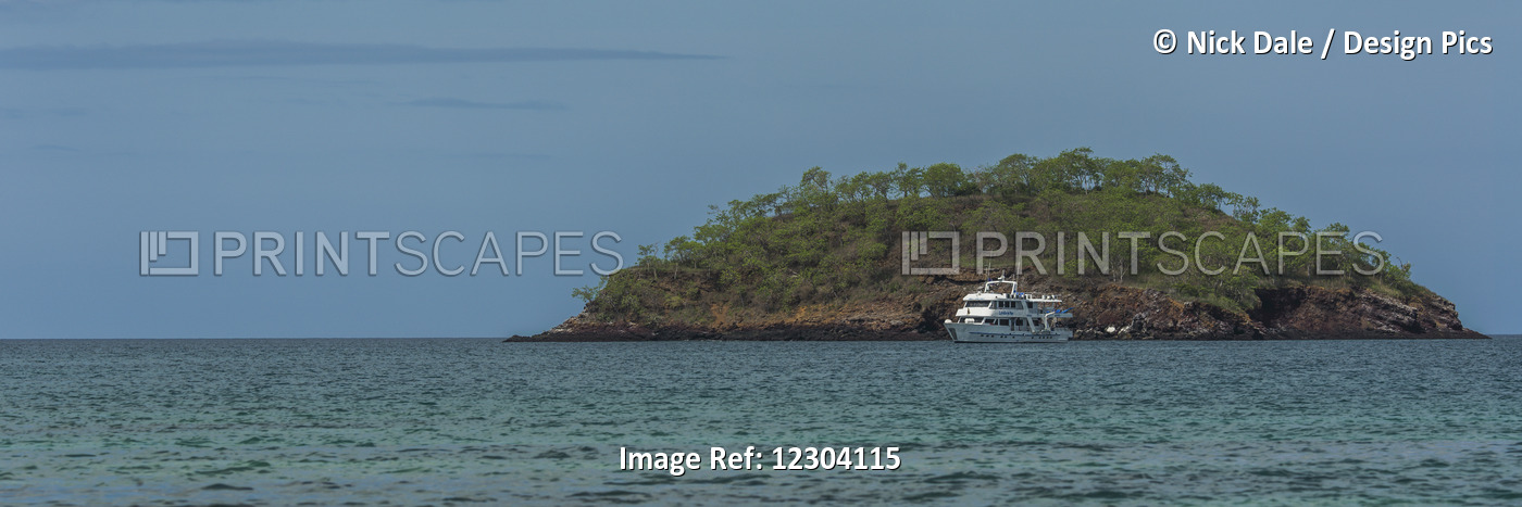 Cruiser Anchored Off Island Under Blue Sky; Galapagos Islands, Ecuador