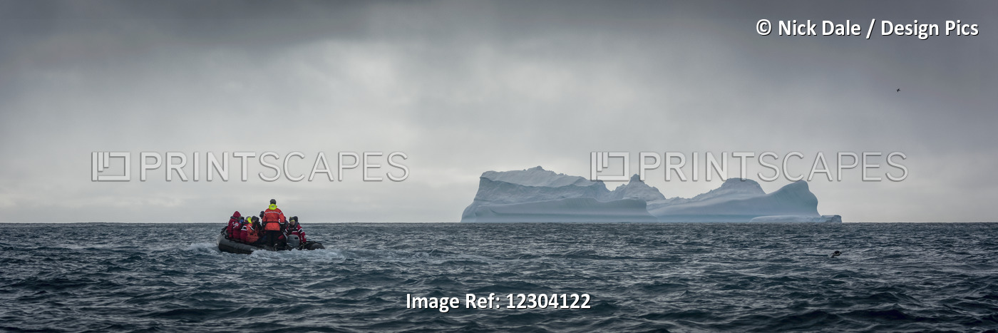 Inflatable Motors Towards Blue Iceberg On Horizon; Antarctica