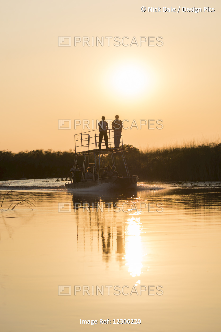 Silhouette Of People On Boat At Sunset; Botswana