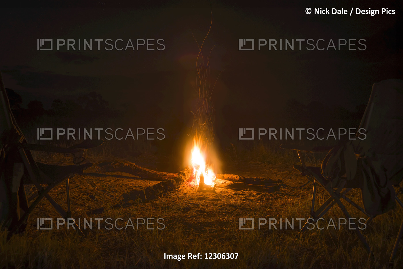 Two Camp Chairs Around Fire At Night; Botswana