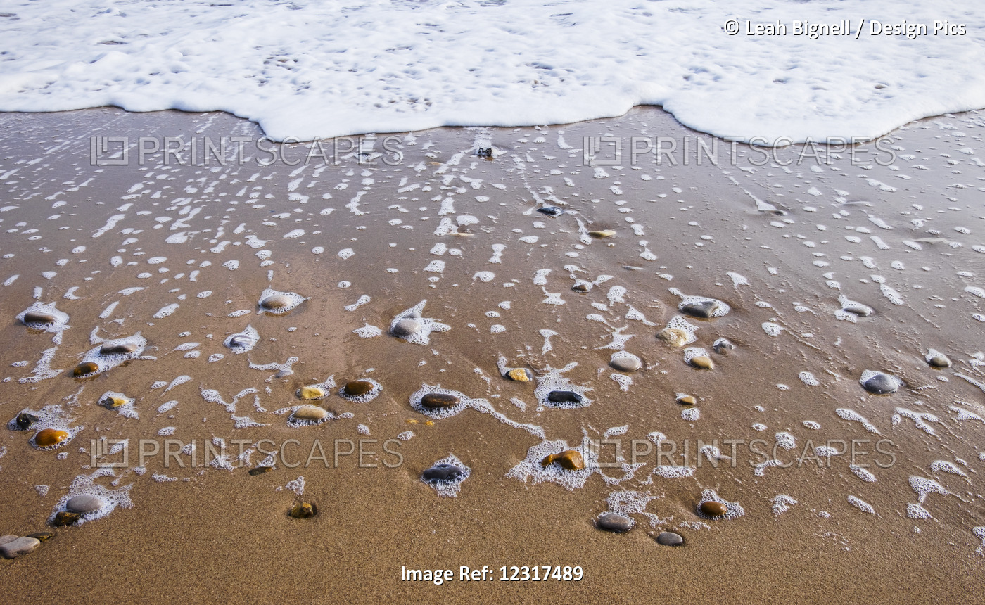 Sea Foam Trails From Beached Pebbles As The Tide Is Pulled Out; South Shields, ...