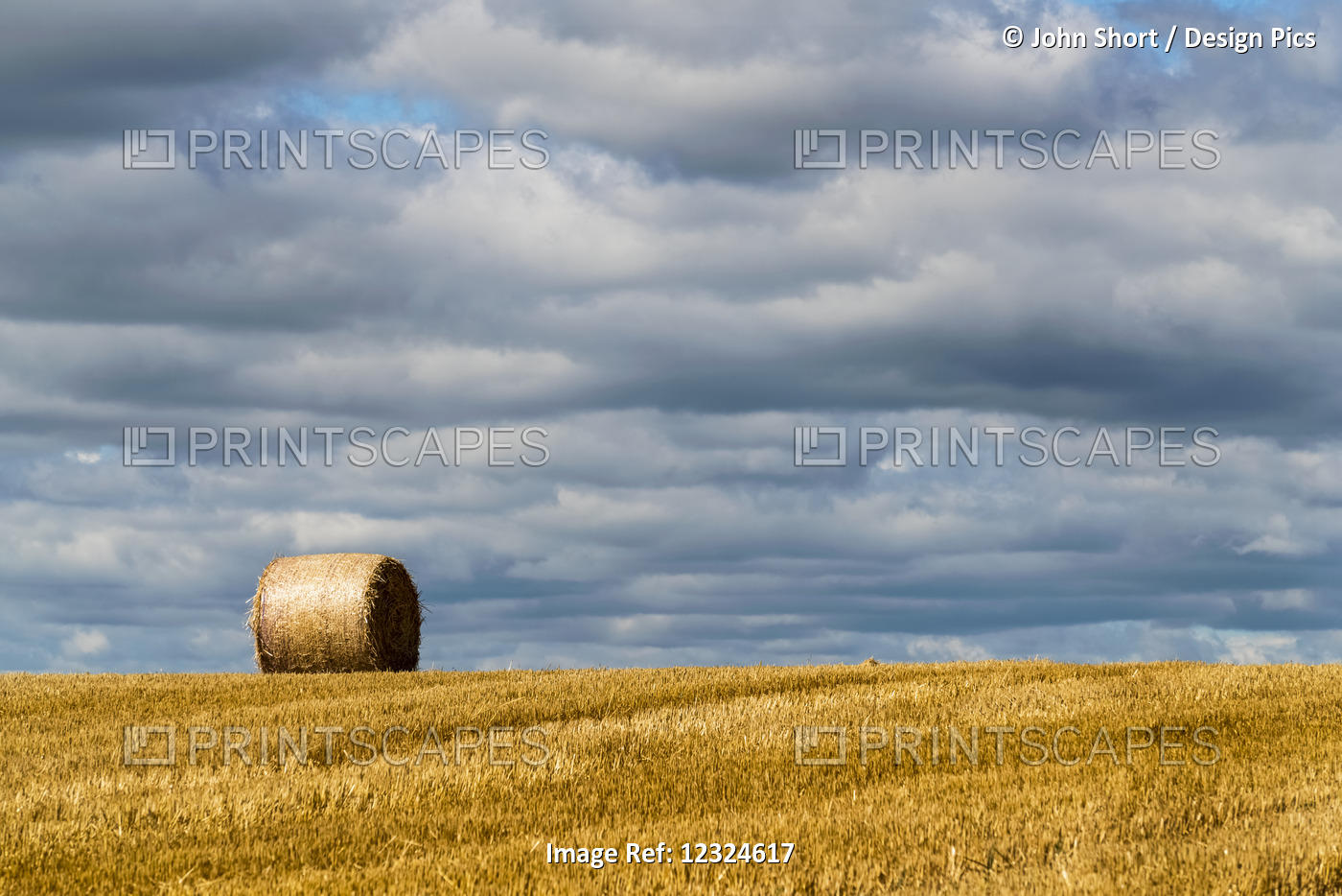A Single Hay Bale On A Cut Field Under A Cloudy Sky; Ravensworth, North ...