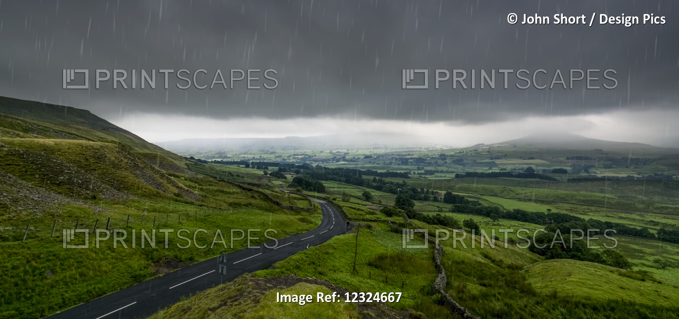 Rain Falling From A Stormy Sky Over A Lush, Green Landscape; North Yorkshire, ...