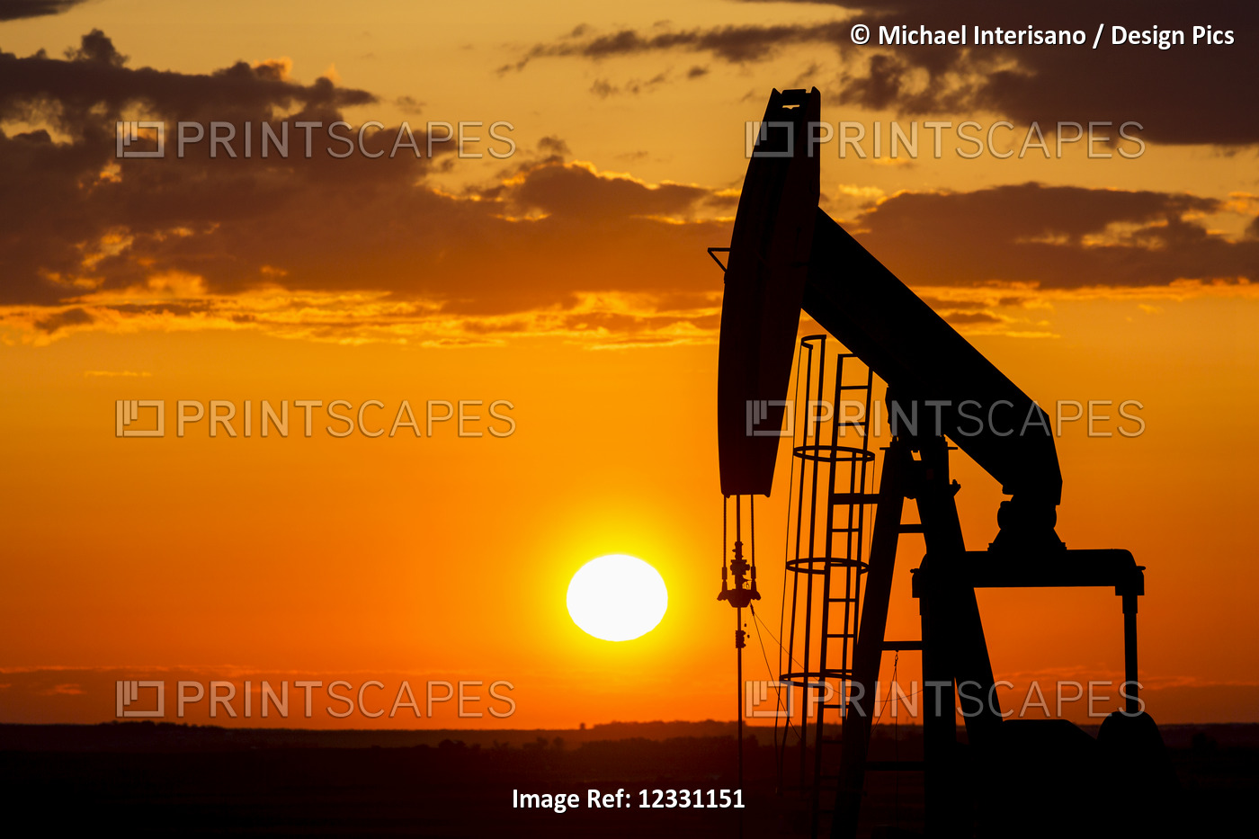 Silhouette Of A Pump Jack At Sunrise With A Colourful Orange Sun, Clouds And ...