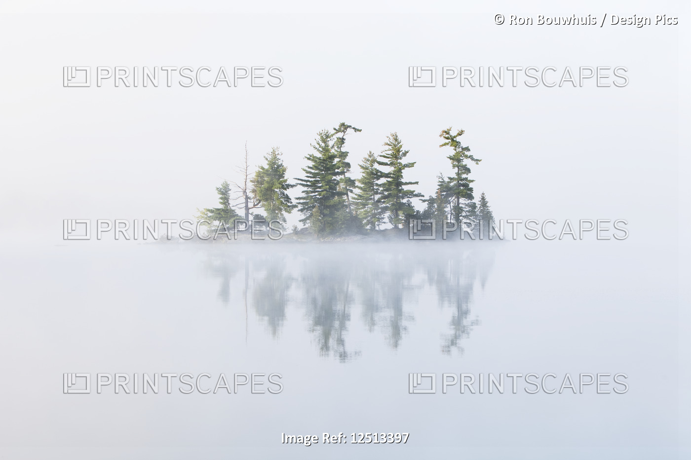 Fog shrouds a small island on Turtle Lake in Ontario's Muskoka Region, near ...