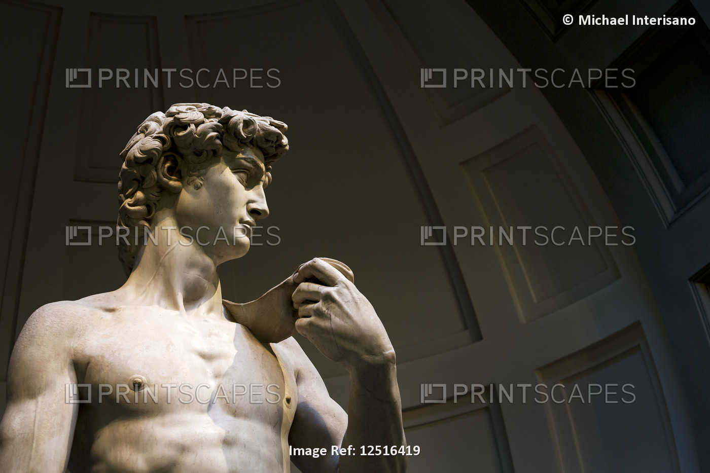 Close-up of 'Michelangelo's David' sculpture with dome in the background; ...
