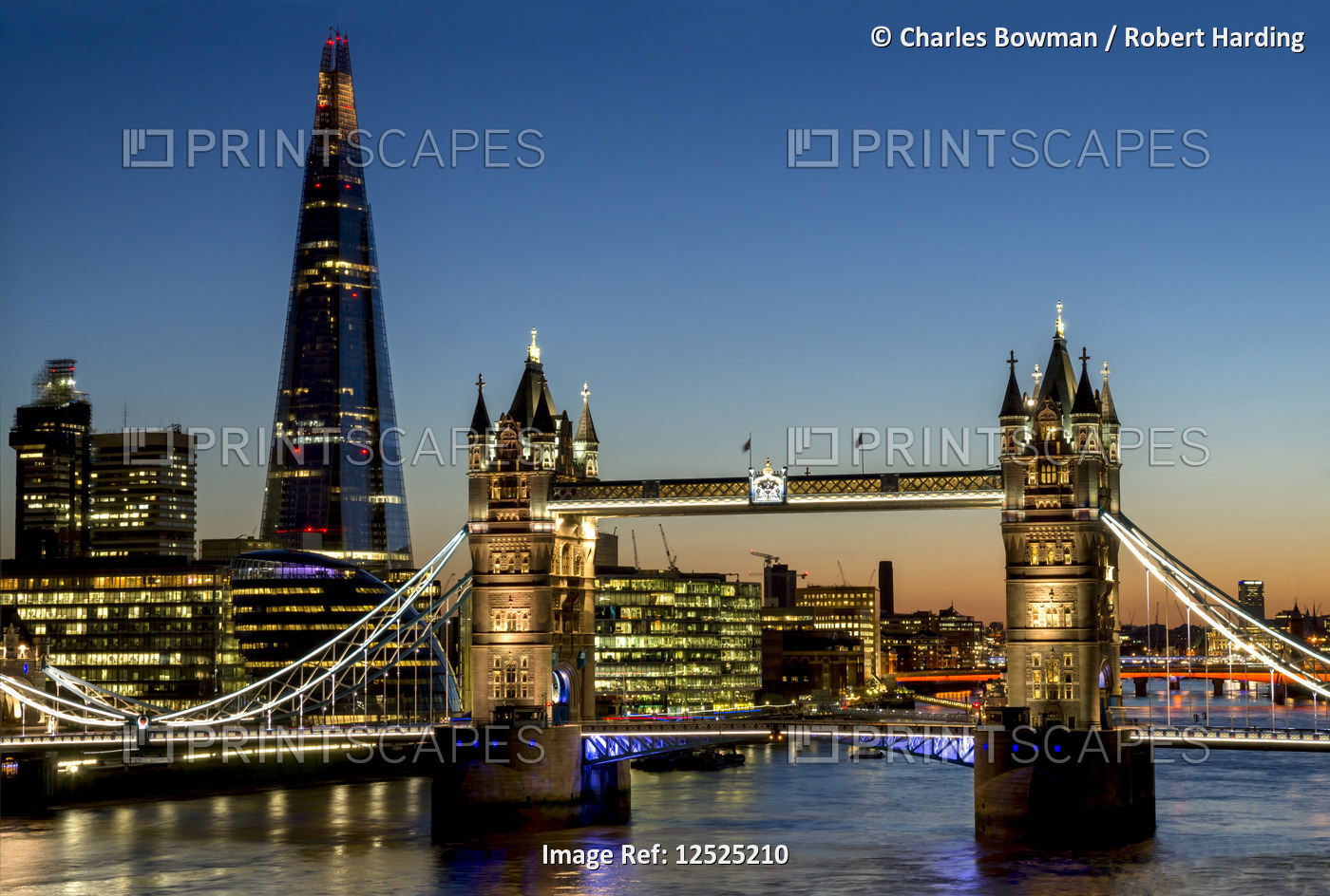 Elevated view shows the Shard and Tower Bridge standing tall above the River Thames at dusk.