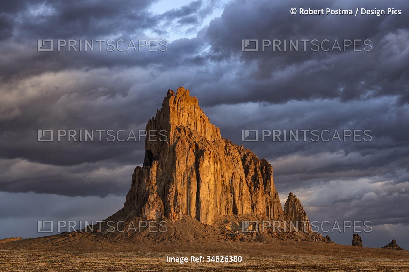 Storm clouds gather over Shiprock, New Mexico. The rising suns illuminates this ...